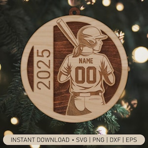 Puede incluir: Adorno de béisbol de madera redondo que representa a una jugadora de béisbol con un bate y el año 2025. La camiseta de la jugadora tiene el número 00 y un nombre encima. El adorno tiene un agujero para colgar.