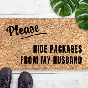 May include: A brown doormat with the text "Please hide packages from my husband" in black lettering.