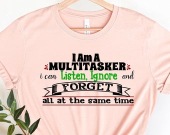 May include: A pink t-shirt with a black and green graphic that says "I am a Multitasker. I can listen, ignore and forget all at the same time."