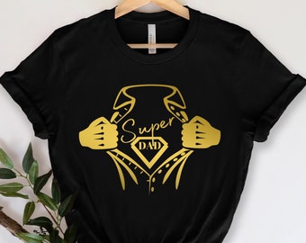 May include: Black t-shirt with a gold graphic of a superhero's chest open revealing a diamond with the text "Super Dad" inside.