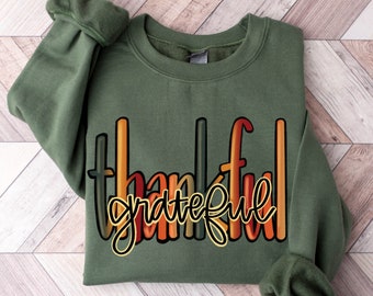 May include: A green sweatshirt with the words "thankful grateful" in a rainbow gradient design.