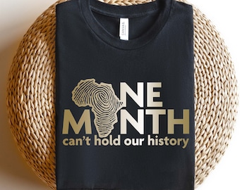 May include: Black t-shirt with a gold outline of the continent of Africa and the text "One Month can't hold our history".