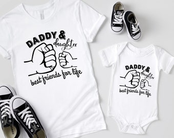 May include: White t-shirt and bodysuit set with black text that reads "Daddy & daughter best friends for life". The design features two fists bumping together.