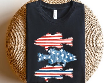 May include: Black t-shirt with a design of three fish in the shape of the American flag. The fish are stacked on top of each other, with the top fish being red, white, and blue stripes, the middle fish being blue with white stars, and the bottom fish being red, white, and blue stripes.
