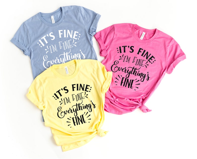 Peut inclure: Trois t-shirts de couleurs diff&eacute;rentes avec le texte "IT'S FINE: IM FINE Everything's FINE" imprim&eacute; dessus.