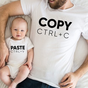 May include: A white t-shirt with the text "COPY CTRL+C" and a white onesie with the text "PASTE CTRL+V".