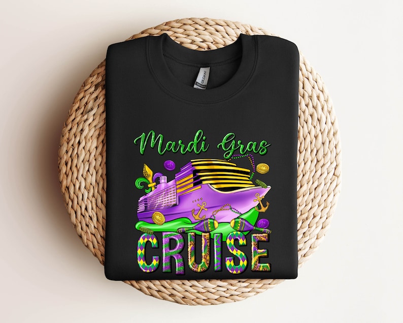 May include: A black t-shirt with a Mardi Gras cruise design. The design features a purple cruise ship with green and gold accents, the words 'Mardi Gras Cruise' in green and gold lettering, and a purple, green, and gold Mardi Gras bead necklace.