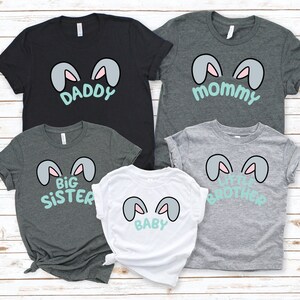 Pu&ograve; includere: Un set di cinque t-shirt con orecchie di coniglio e testo. Le magliette sono di colore grigio, nero e bianco. Il testo sulle magliette recita "Pap&agrave;", "Mamma", "Sorella Maggiore", "Fratello Minore" e "Baby".