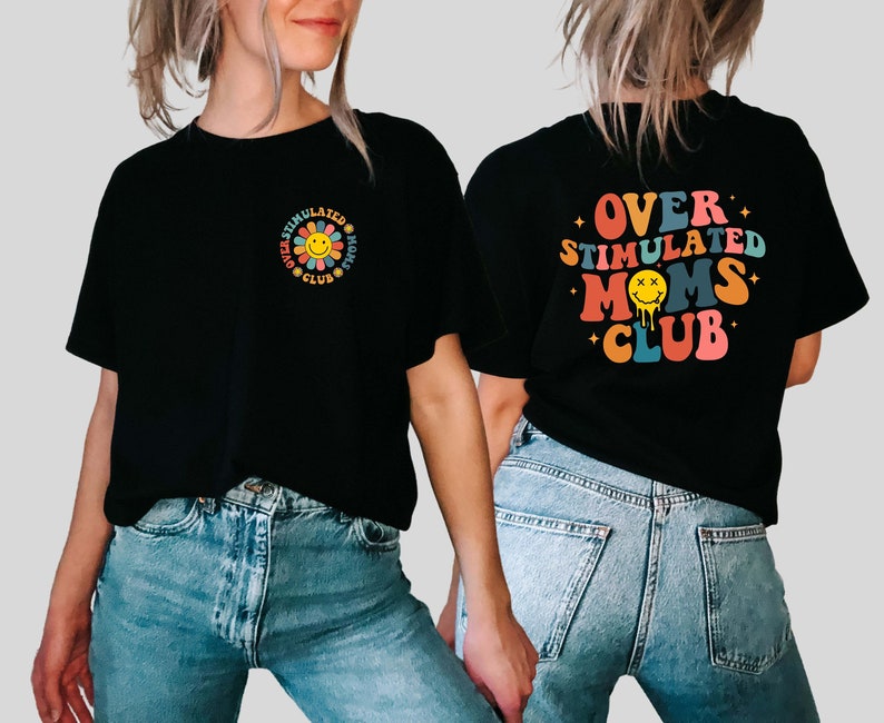 May include: Black t-shirt with the text "Over Stimulated Moms Club" in rainbow colors with a yellow smiley face with x's for eyes. The shirt is being worn by a person with blue jeans.