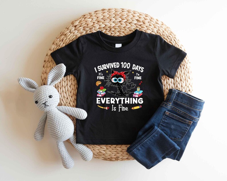 May include: Black t-shirt with the text "I Survived 100 Days Everything Is Fine" and a cartoon cat wearing a red headband. The shirt is paired with blue jeans and a gray stuffed bunny.