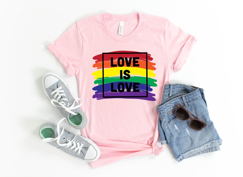 May include: Pink t-shirt with a rainbow graphic and the text "LOVE IS LOVE" in a black square.