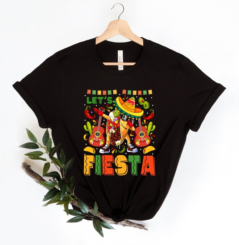 May include: Black t-shirt with a cartoon taco wearing a sombrero and holding a guitar. The text "Let's Fiesta" is printed on the shirt.