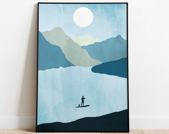 May include: Abstract art print featuring a serene landscape with a person paddleboarding on a lake. The artwork uses shades of blue and green to depict mountains, water, and a bright moon. The print is framed in a black border.