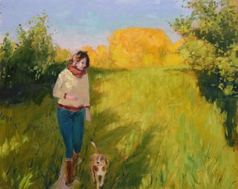 Könnte beinhalten: Eine Frau in einem cremefarbenen Pullover und blauen Jeans geht mit einem kleinen braunen und weißen Hund über ein Feld. Das Feld ist grün und gelb mit Bäumen im Hintergrund.