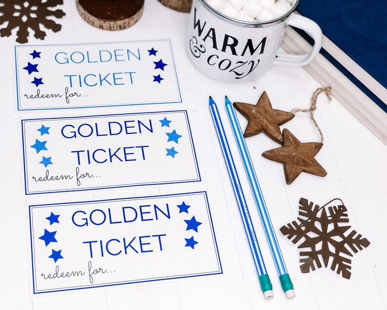 以下が含まれることがあります： 白い木製の表面に、青い星と「GOLDEN TICKET redeem for... 」という文字が書かれた、白い印刷可能な金のチケットカードが3枚。茶色の木製の星と雪の結晶が置かれている。