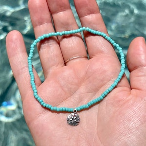 Cute stretchy anklet or bracelet made with Toho round 8/0 seed beads in your choice of color with a small sterling silver sand dollar charm