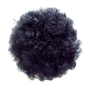 May include: A round, dark black hairpiece, likely a wig or hair accessory, against a plain white background. The hair appears to be tightly curled or textured, creating a dense, voluminous appearance. The overall shape is circular.