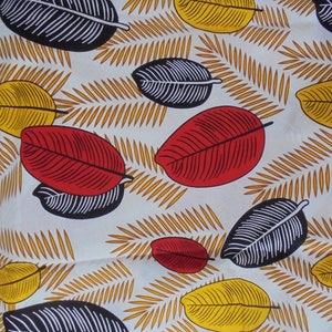 May include: White fabric with a repeating pattern of black, red, and yellow leaves. The leaves are stylized and have a graphic design.