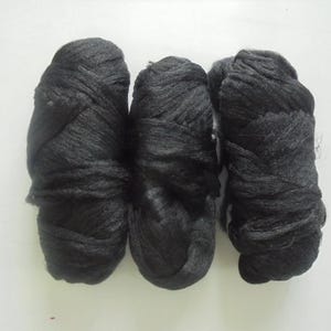 May include: Three balls of black yarn, each wound into a ball shape.