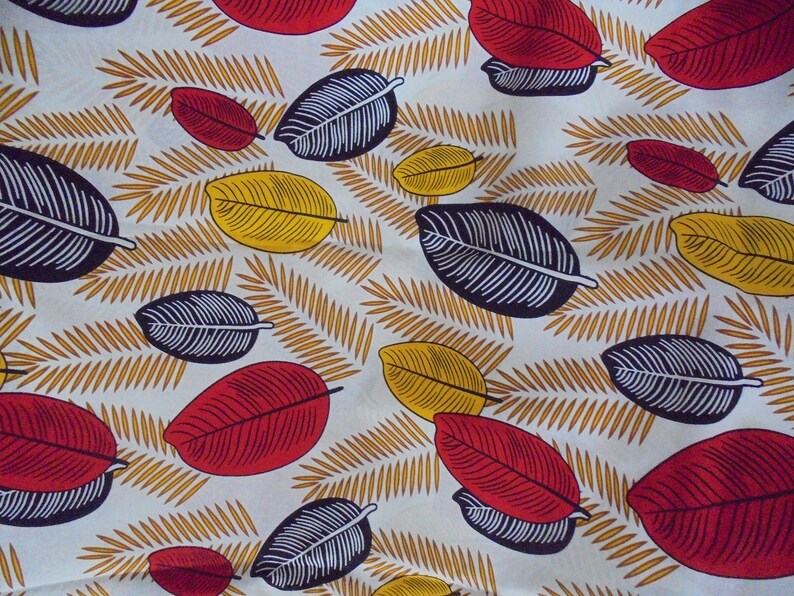 May include: White fabric with a repeating pattern of black, red, and yellow leaves. The leaves are stylized and have a graphic design.