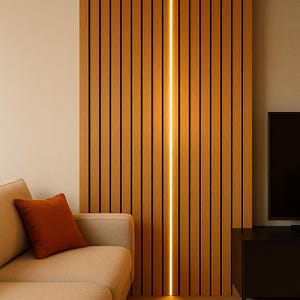 Könnte beinhalten: Ein modernes Wohnzimmer mit einem hellen Sofa und einem orangefarbenen Kissen. Eine Holzlattenwand mit einem vertikalen Lichtstreifen ist der Mittelpunkt. Ein schwarzes Unterhaltungsmöbel und ein Fernseher sind ebenfalls zu sehen.