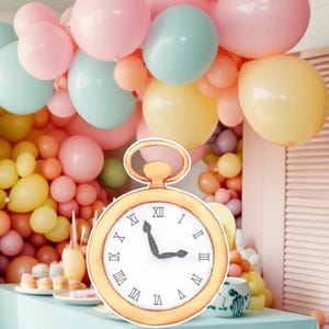 May include: A gold pocket watch with Roman numerals on the face. The watch is surrounded by pastel-colored balloons.