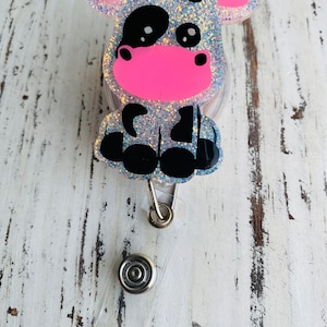 Sitting black cow badge reel