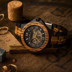 May include: A wristwatch featuring a round wooden bezel with Roman numerals and a skeleton dial revealing internal mechanical gears. The band is constructed from alternating black and wood-grain links with a gold-tone center accent line.