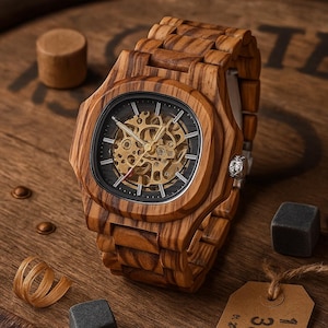 May include: A wooden wristwatch with a square face and a visible mechanical movement. The watch has a zebrawood grain pattern and a matching wooden band. The watch is displayed on a wooden surface.
