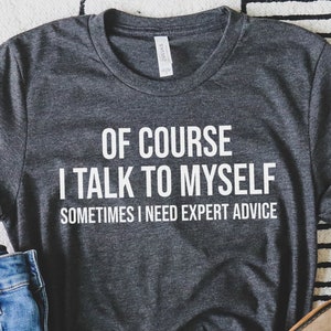 May include: A dark gray t-shirt with white text that reads "Of course I talk to myself. Sometimes I need expert advice."