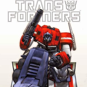Puede incluir: Un robot rojo y azul, Optimus Prime, se transforma en un coche azul. La imagen es de la serie de cómics Transformers. El texto "TRANSFORM AND ROLL OUT!" está en la parte inferior de la imagen.
