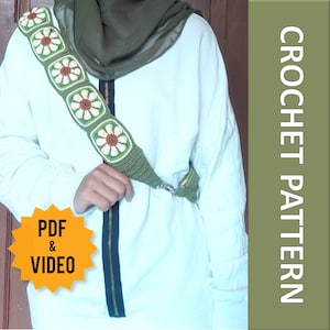 May include: A crocheted strap with a floral design in white, green, and brown. The strap is attached to a white garment with a dark green zipper. The image also includes the text "CROCHET PATTERN" and "PDF & VIDEO".