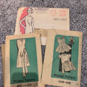 May include: Two vintage sewing patterns, one for a dress and pants, the other for a dress and jacket. The pattern for the dress and pants is labeled "Printed Pattern 4892 - SIZE 14". The pattern for the dress and jacket is labeled "Printed Pattern 9329 - SIZE 6".