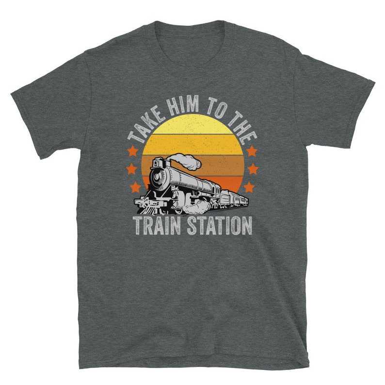May include: A dark heather grey t-shirt with a vintage-style graphic of a train with the text "Take Him To The Train Station".
