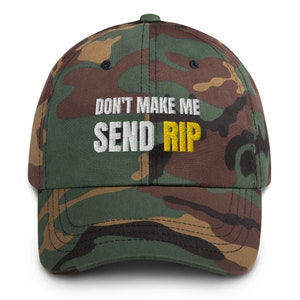 Puede incluir: Una gorra de b&eacute;isbol de camuflaje con el texto "DON'T MAKE ME SEND RIP" bordado en blanco y amarillo.
