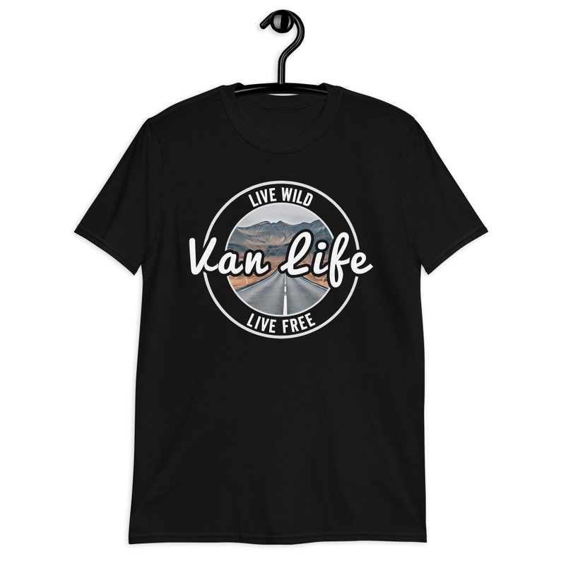 May include: Black t-shirt with a white circle graphic that says "Live Wild Van Life Live Free" with a picture of a road in the mountains.