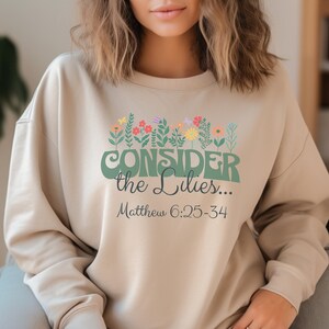 Betrachten Sie das Lilies-Sweatshirt: Der Blumenbibel-Vers der christlichen Frauen