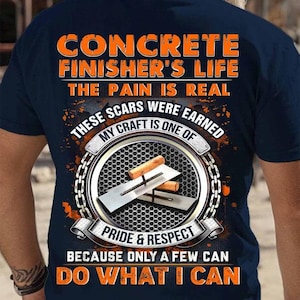 Puede incluir: Una camiseta azul marino con texto naranja que dice "Concrete Finisher's Life The Pain Is Real These Scars Were Earned My Craft Is One Of Pride & Respect Because Only A Few Can Do What I Can". La camiseta presenta un gráfico circular con una llana y las palabras "Pride & Respect" en naranja.