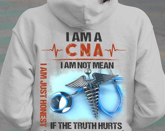 May include: White hoodie with the text "I AM A CNA I AM NOT MEAN I AM JUST HONEST IF THE TRUTH HURTS HERE TAKE A BAND-AID". The design includes a caduceus, a stethoscope, and a heartbeat line.