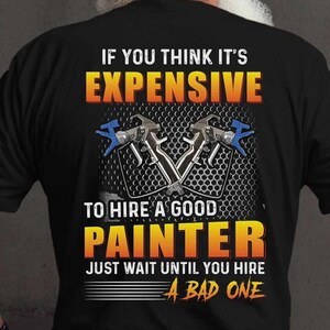 May include: Black t-shirt with the text "IF YOU THINK IT'S EXPENSIVE TO HIRE A GOOD PAINTER JUST WAIT UNTIL YOU HIRE A BAD ONE." The shirt features a graphic of two crossed paint spray guns.