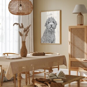 May include: A black and white line drawing of a dog named Winston on a woodgrain background. The drawing is framed and hanging on a wall in a dining room with a wooden table, chairs, and a woven lampshade.