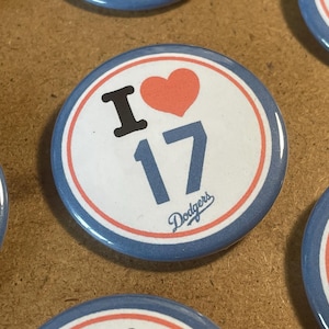 May include: Round button with a white center, featuring a black "I" and a red heart above the number "17" in blue. The word "Dodgers" is printed below the number. The button has a blue and white border.
