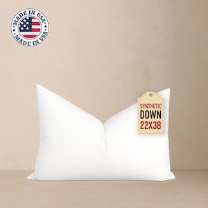 May include: A white synthetic down pillow, measuring 22 x 38 inches, with a tag that reads "SYNTHETIC DOWN 22X38". The pillow is displayed against a neutral background. A "MADE IN USA" emblem is visible.