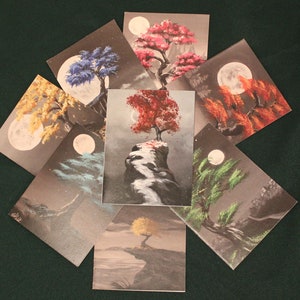 May include: Set of eight cards featuring a stylized tree with a full moon in the background. Each card depicts a different color tree, including red, blue, green, yellow, and brown.