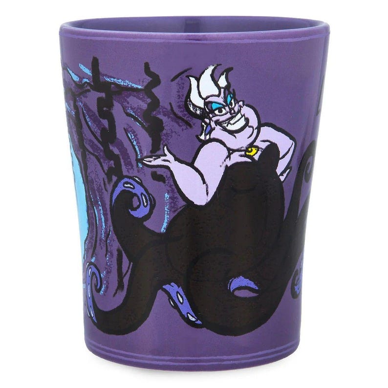 May include: A purple tumbler featuring the Disney villain Ursula from The Little Mermaid. The illustration shows Ursula with her tentacles and a menacing expression. The tumbler is cylindrical and made of a glossy material.