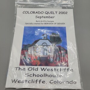 May include: A packaged quilt pattern titled "COLORADO QUILT 2002 September" by Barb Griffin Designs. The pattern features an illustration of the Old Westcliffe Schoolhouse in Westcliffe, Colorado. The image is in a clear plastic bag.