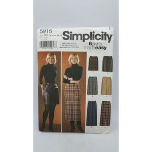 May include: Simplicity sewing pattern 5915 for six skirts. The pattern features images of the skirt styles and a woman wearing a leather skirt and a plaid skirt. The pattern includes sizes R5: 14, 16, 18, 20, and 22.