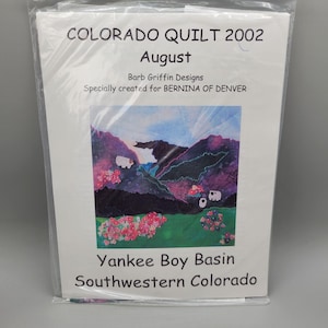 May include: A packaged quilt pattern titled "COLORADO QUILT 2002 August" by Barb Griffin Designs. The pattern features a colorful landscape scene of Yankee Boy Basin in Southwestern Colorado, with mountains, flowers, and sheep.