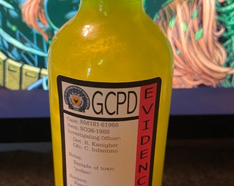 Peut inclure: Une bouteille en verre jaune avec un bouchon noir et une étiquette rose qui indique "GCPD EVIDENCE HAZARDOUS". L'étiquette comprend également les numéros de cas et d'article, le nom de l'officier enquêteur et des notes sur le contenu.