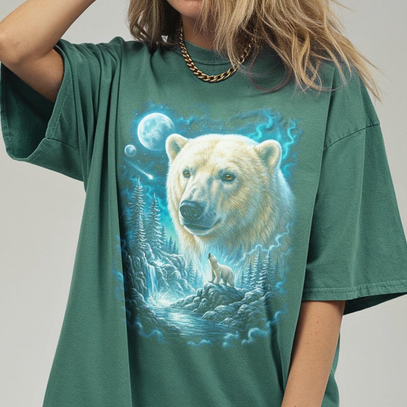May include: Green t-shirt with a detailed illustration of a polar bear and cub, a waterfall, and a moonlit sky. The bear is white and the shirt is a solid green colour.